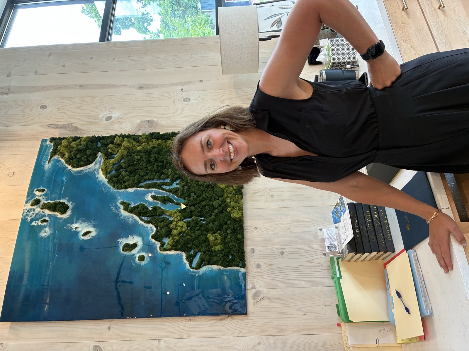 Aerial lake art hung on a wood-panel wall